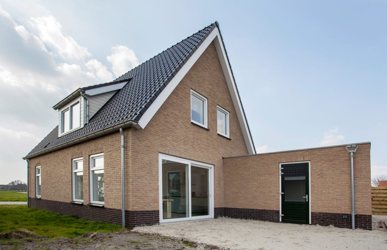 Nieuwbouwwoning met enkele Gealan kunststof schuifpui in wit kozijn, geplaatst in een bakstenen gevel – Toelevering Online